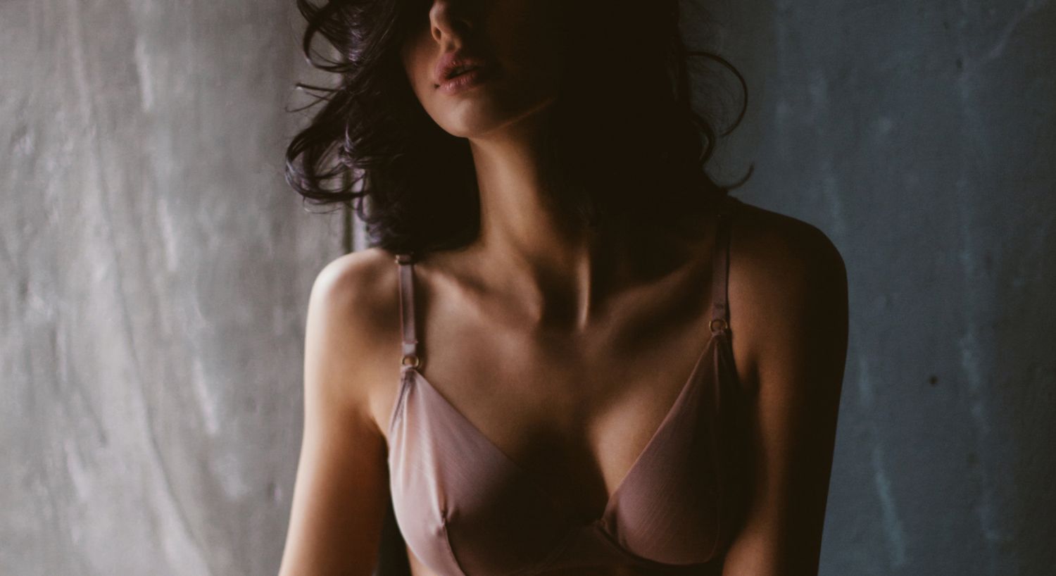 Woman in lingerie against a textured background.